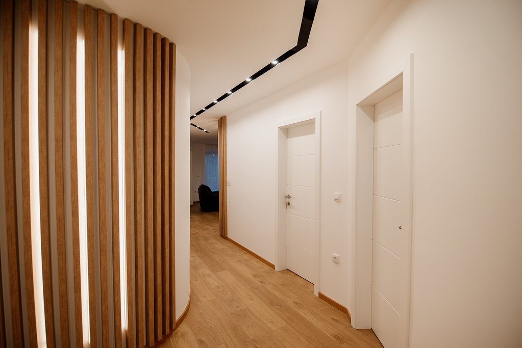 Modern hallway with wooden flooring and interior doors showing finished residential installation