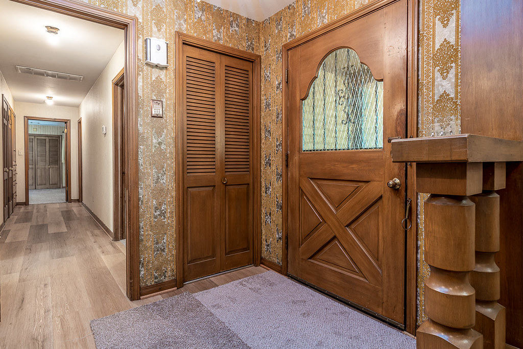 Luxury vinyl plank flooring installed in a residential hallway with wood doors